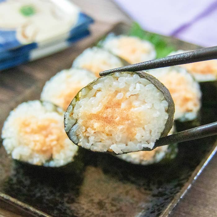 明太マヨのり巻きが箸で持ち上げられ、他の寿司が皿に並んでいる。