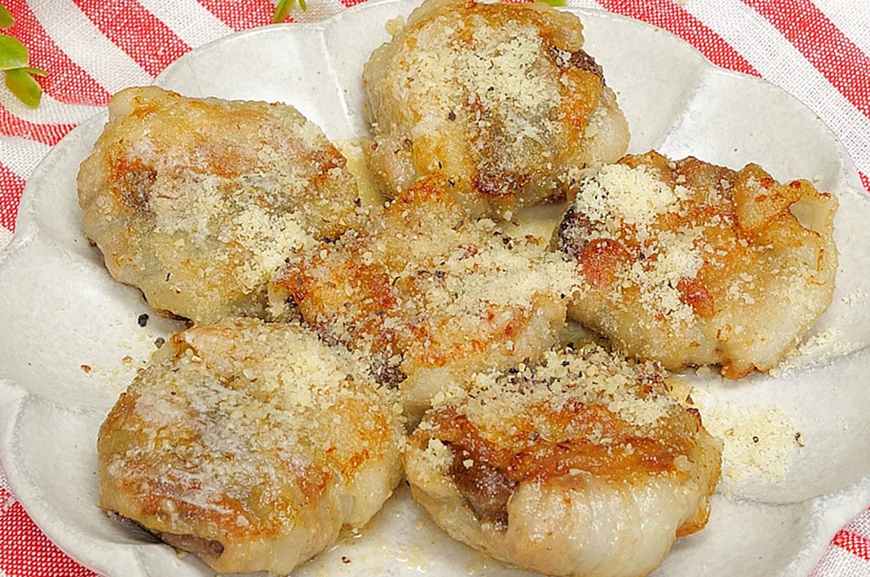 小皿に盛られたエビ餃子6個とテーブルクロスの上に置かれた緑の植物。