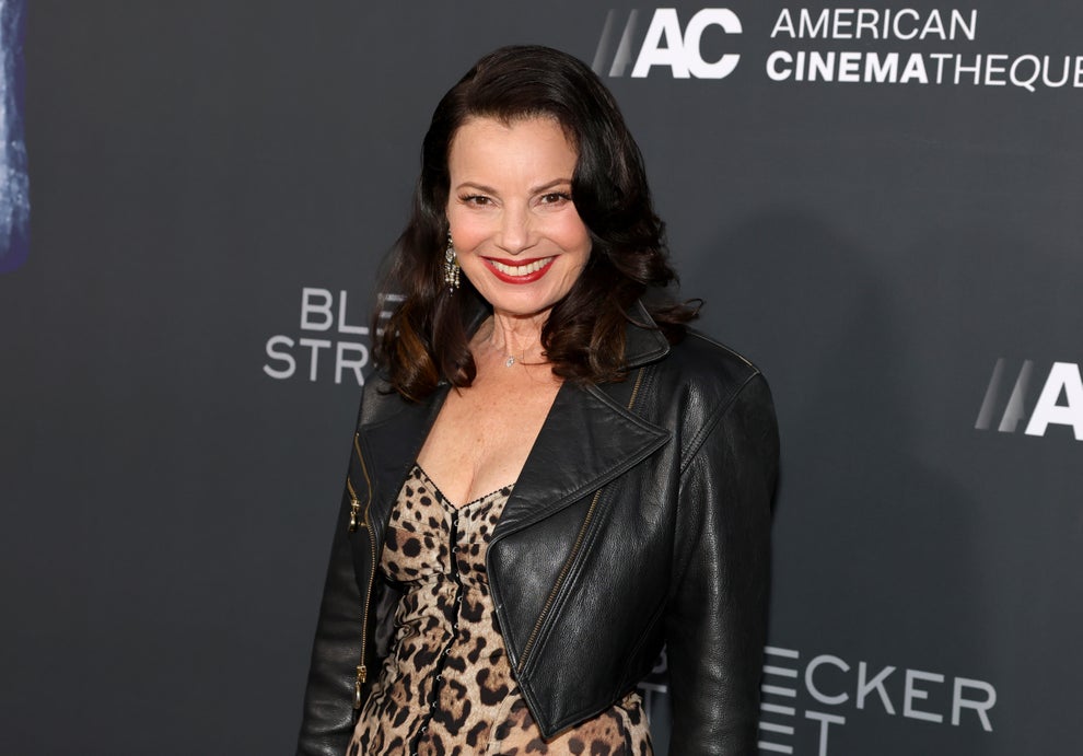 24 Bizarre Celeb Facts That Sound Fake, But Are 100% True 28 Person in a leopard-print dress and black leather jacket smiles at a film event backdrop