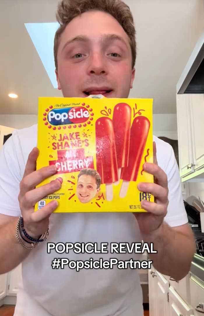 Person holding a popsicle box with their face on it, text reads: "POPSICLE REVEAL #PopsiclePartner."