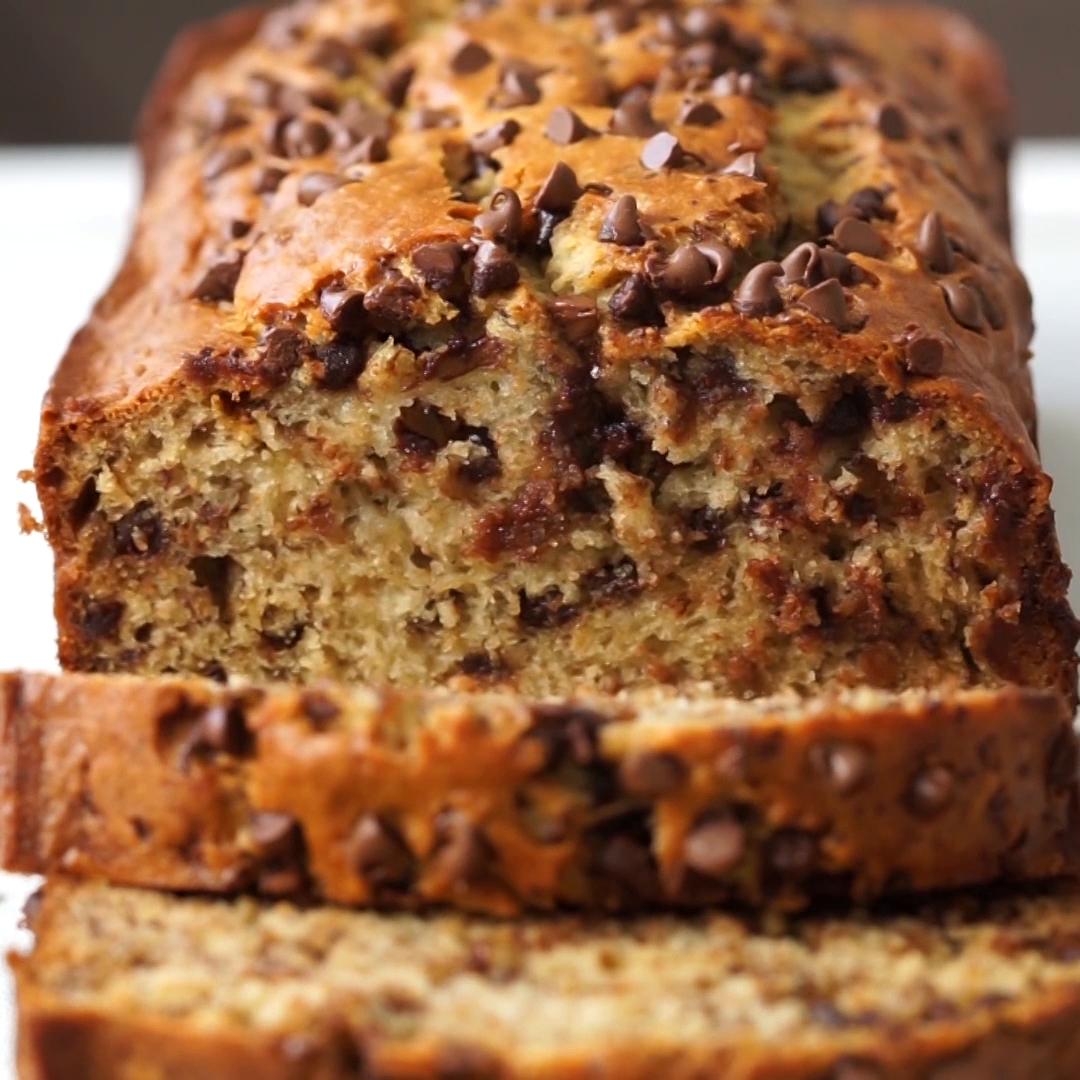Close-up of a sliced banana bread loaf topped with chocolate chips, showcasing its moist texture and rich chocolatey appearance