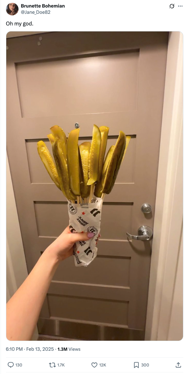 Person holding bouquet of pickles successful  beforehand   of a door, shared successful  a humorous societal  media post