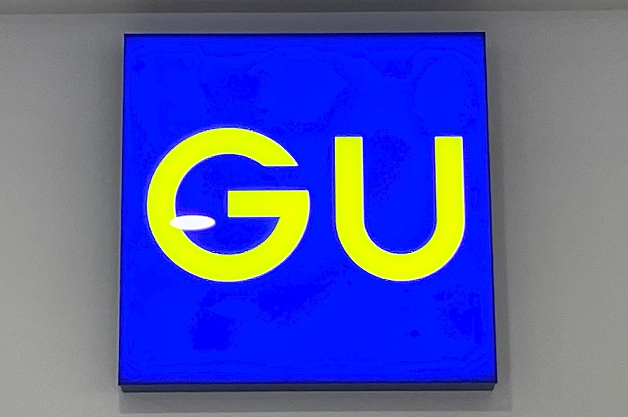 GUの店舗サイン。青い背景に黄色の「GU」ロゴが表示されています。