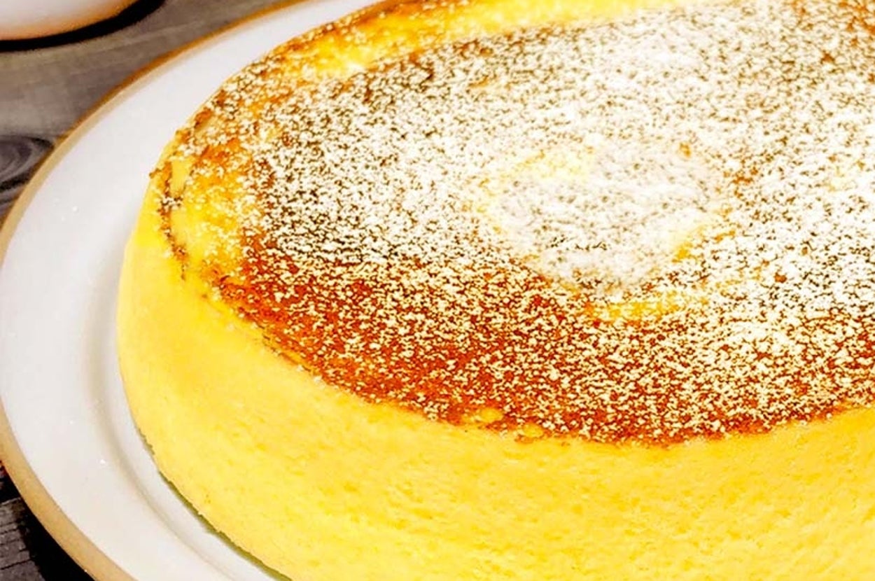 ふわふわのスフレチーズケーキが皿に盛られており、上には粉砂糖が軽く振りかけられている。