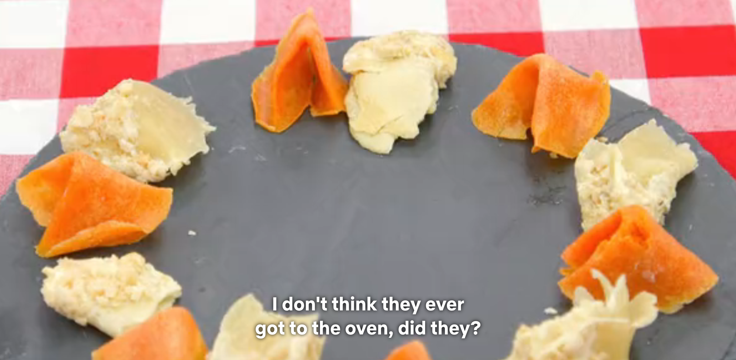A round plate with scattered uncooked dumplings; subtitles read, "I don't think they ever got to the oven, did they?"