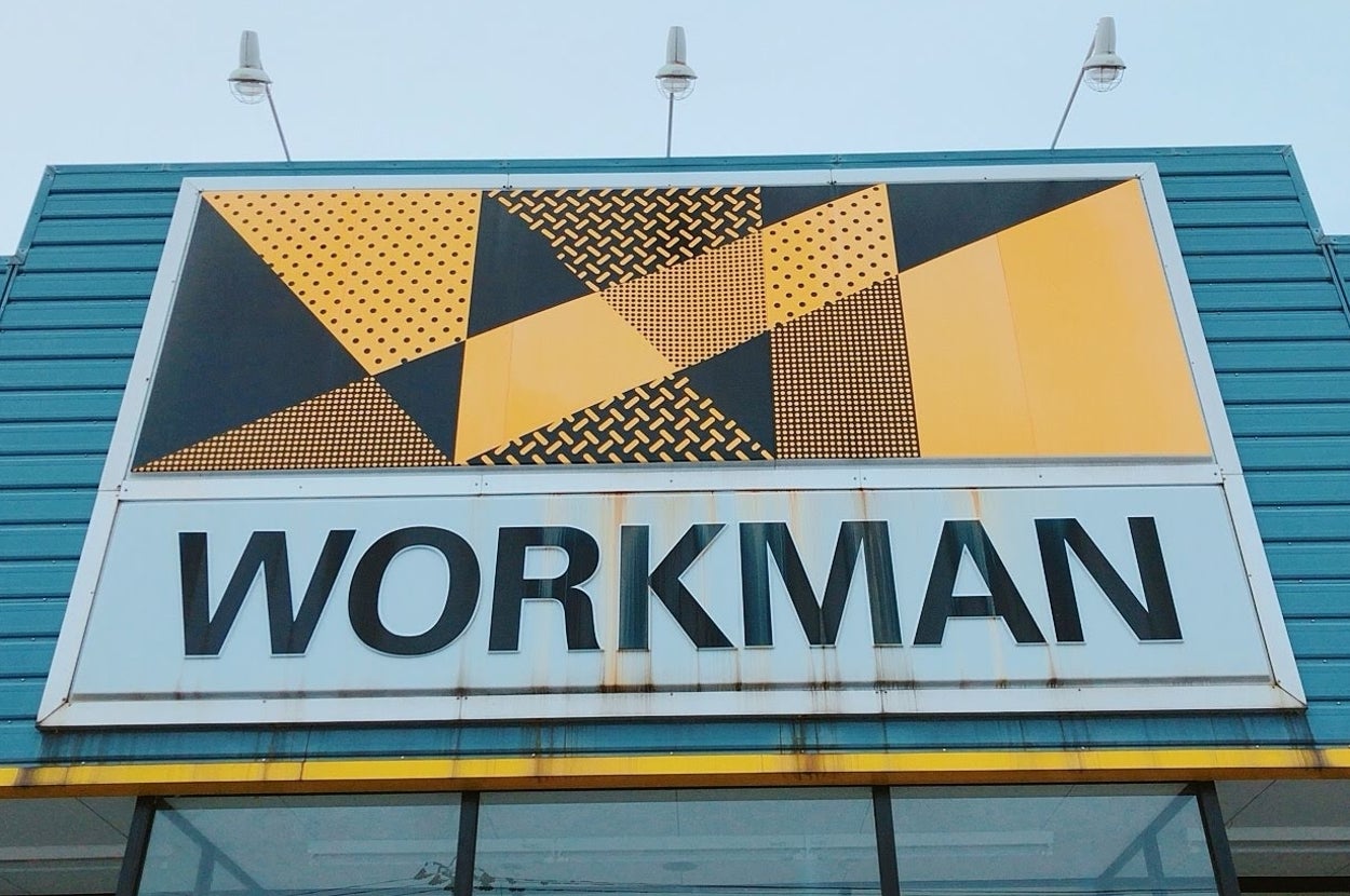 Store entrance with patterned sign reading "WORKMAN" on the facade, featuring abstract geometric shapes