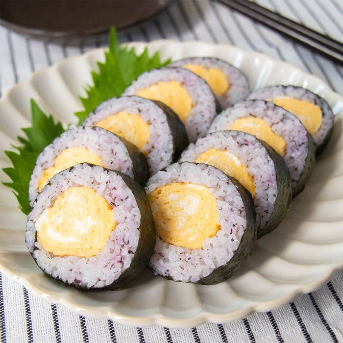 皿に盛られた卵焼き入りのゆかりのり巻き。大葉が添えられている。