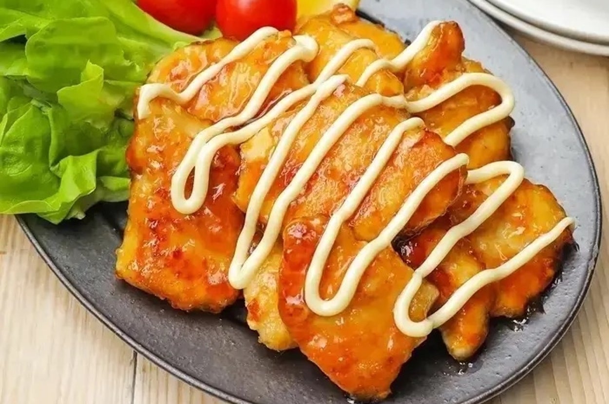 皿に盛られたチキン料理、サラダとトマト添え、マヨネーズがかかっている。
