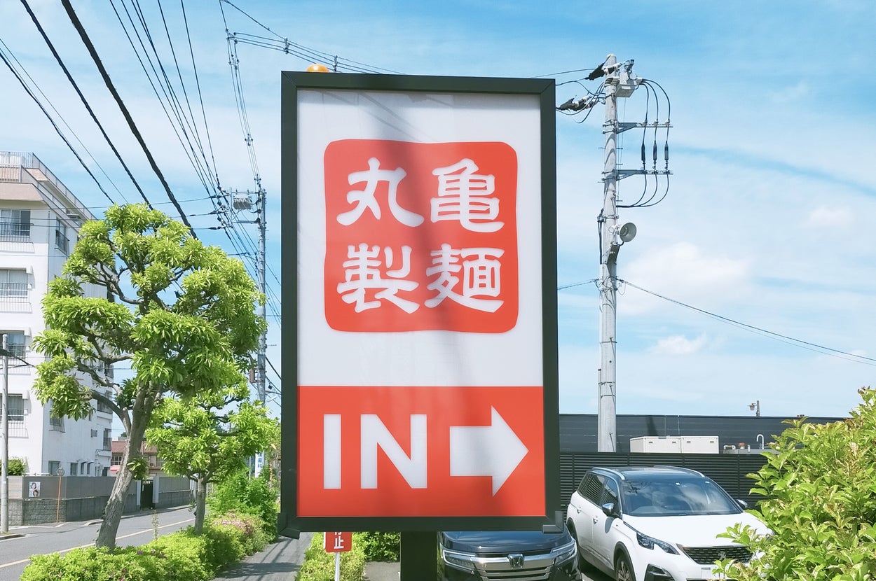 丸亀製麺の駐車場案内看板。右方向を示す矢印が描かれている。