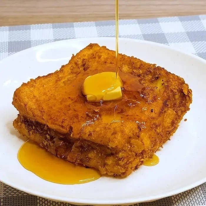 フレンチトーストにバターが乗っており、シロップがかけられている様子。