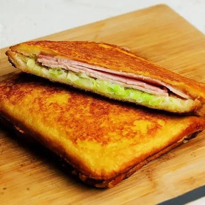 ハムとキャベツを挟んだトーストサンドイッチが食卓に置かれている。