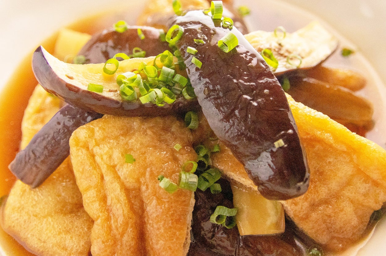 揚げ出し豆腐とナスの煮物、刻みネギがトッピングされている皿盛りの料理。