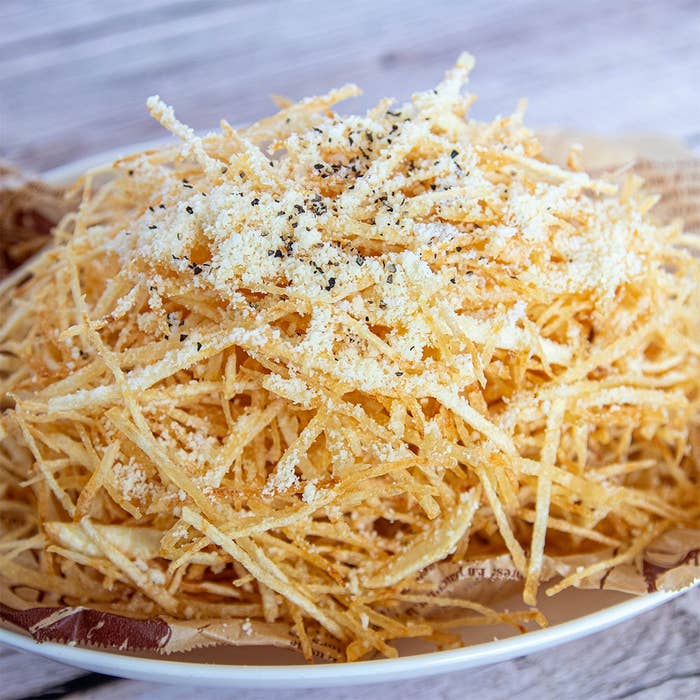 細切りのポテトが山盛りに盛られ、パルメザンチーズと黒胡椒がかかっている料理。