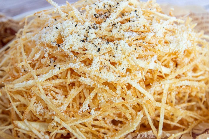 細切りポテトフライが盛られた皿。上に粉チーズと黒こしょうがかけられている。