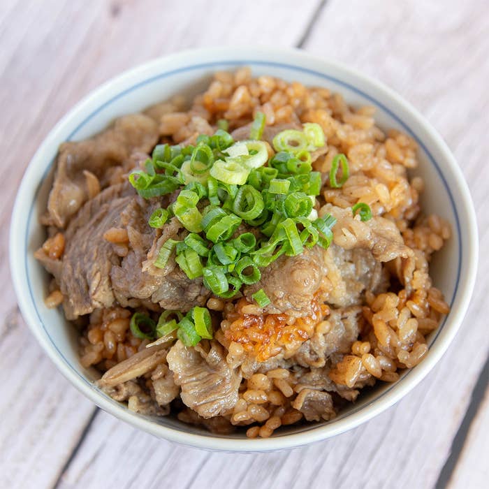 牛肉と刻みネギがトッピングされた炊き込みご飯。手作り感のある温かそうな一品。