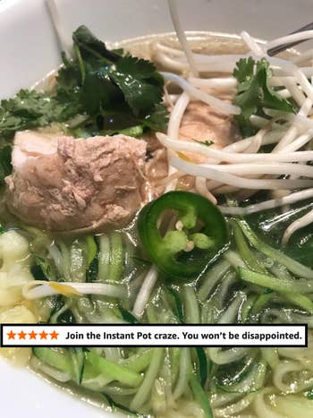 Close-up of a vessel of pho with noodles, legume sprouts, cilantro, sliced jalapeño, and chunks of nutrient successful broth