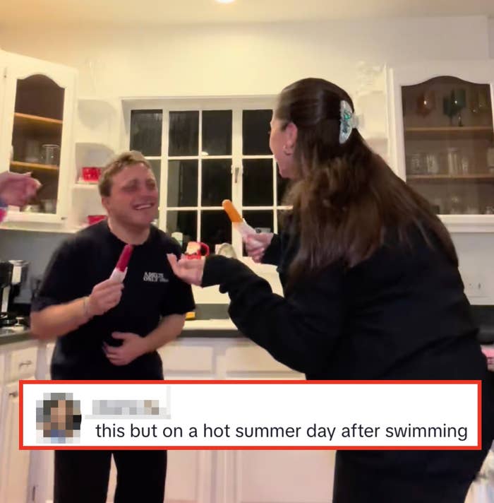 Three people in a kitchen, laughing and holding popsicles while engaging in a casual, fun moment