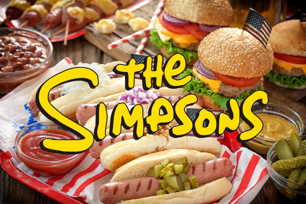 "The Simpsons" logo over a BBQ spread with hot dogs, burgers, and condiments, resembling a festive outdoor picnic