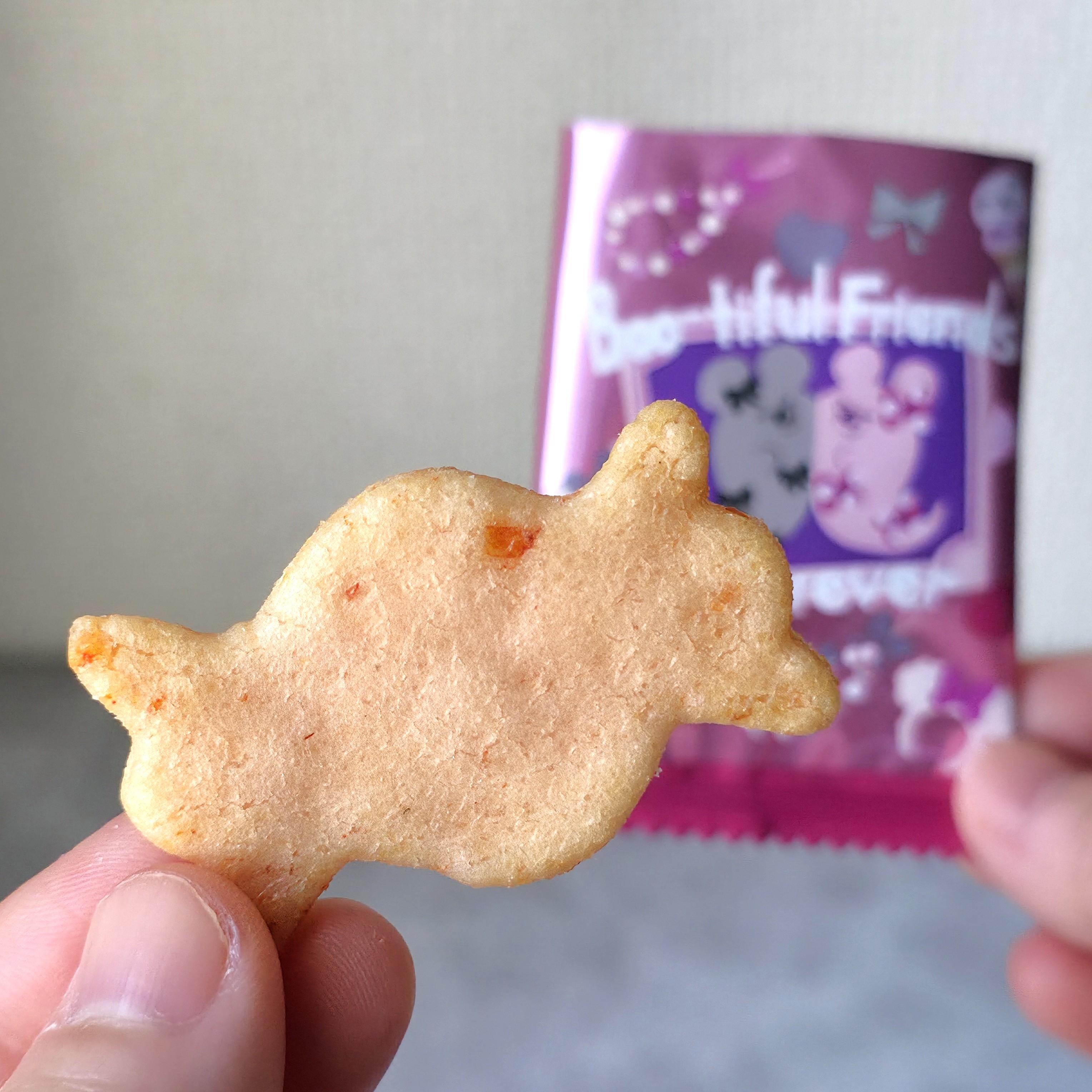手に持った動物型のスナック菓子と、そのパッケージが写っています。