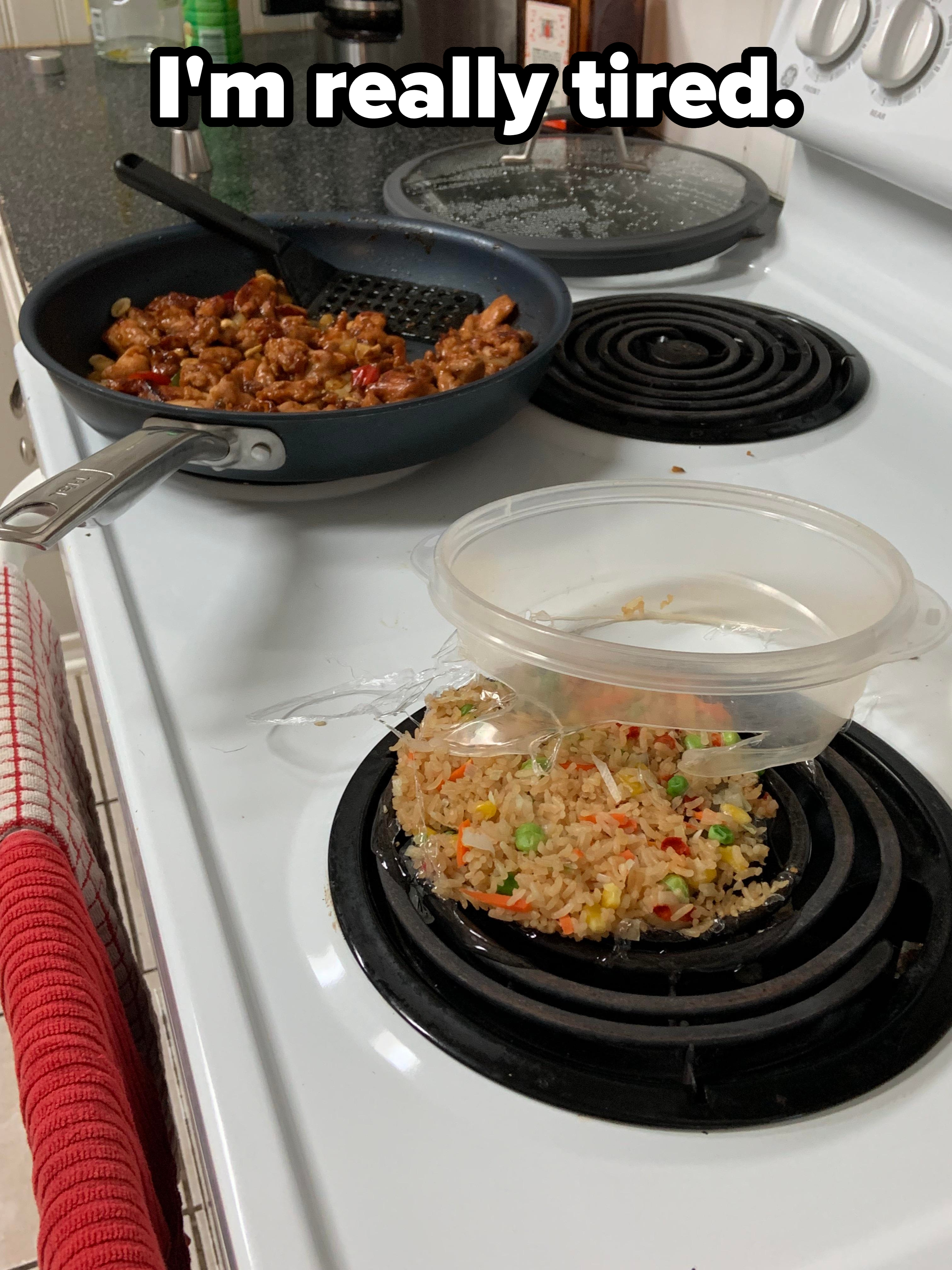 Stir-fried chicken in a pan on a stove with spilled fried rice and peas from an overturned container on a burner