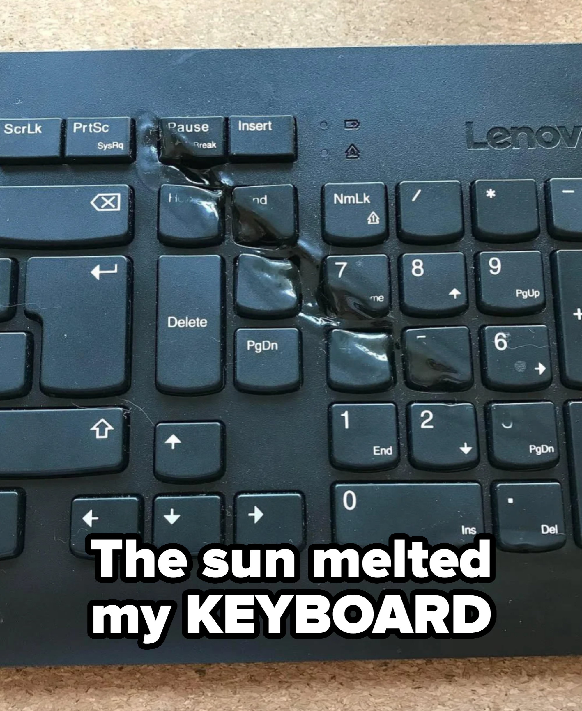 Melted keyboard with distorted keys, possibly from heat damage, showing unrecognizable letters and a warped surface