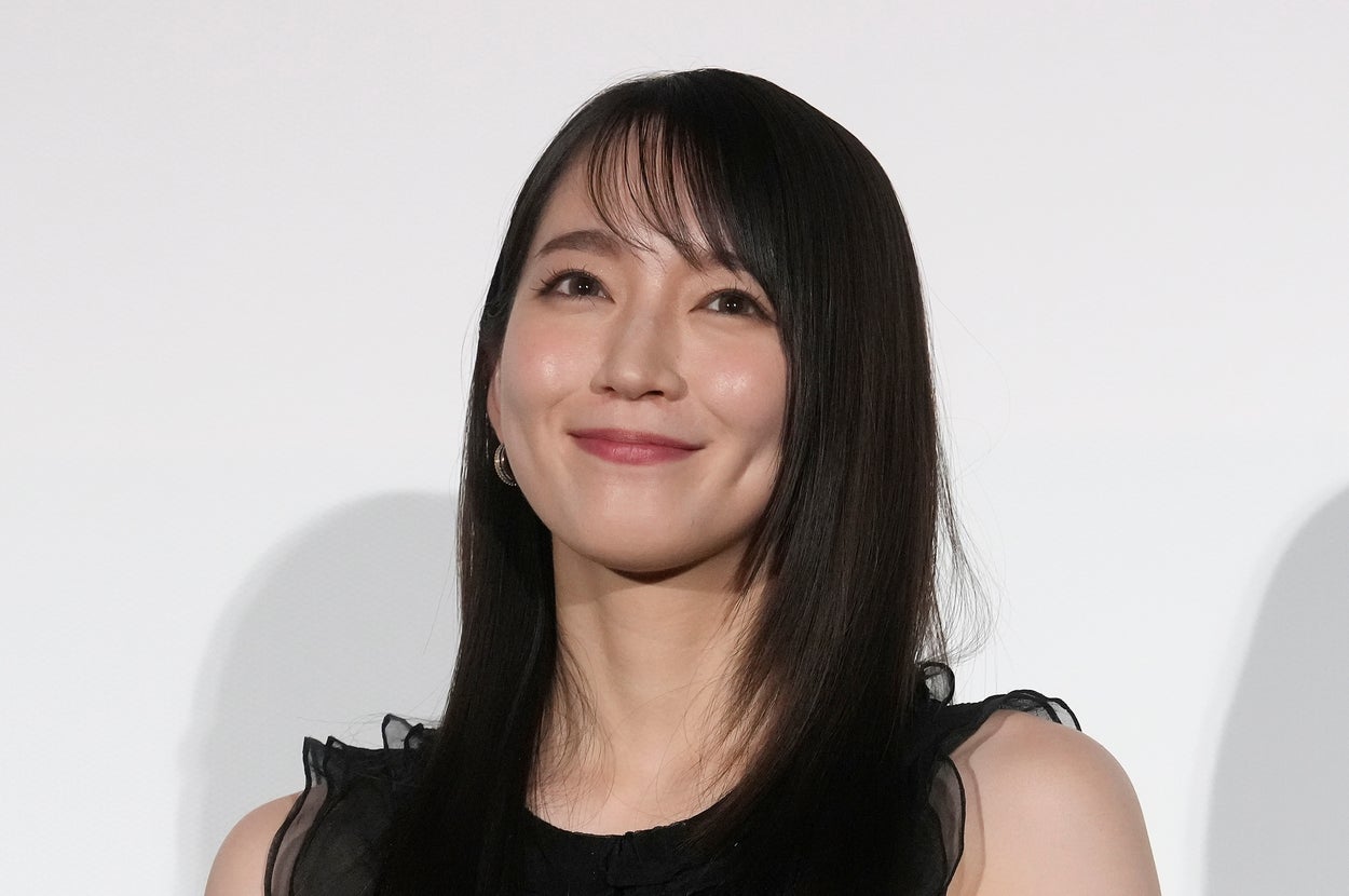 有名人が黒のエレガントなドレスを着て微笑んでいる。