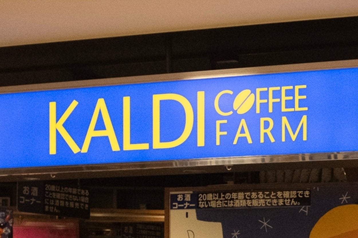 カルディの店舗外観。棚に商品がぎっしり並び、店頭には特価の張り紙やカートが配置されている。