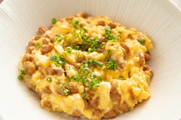 器に盛られた納豆とスクランブルエッグ、大葉がトッピングされています。