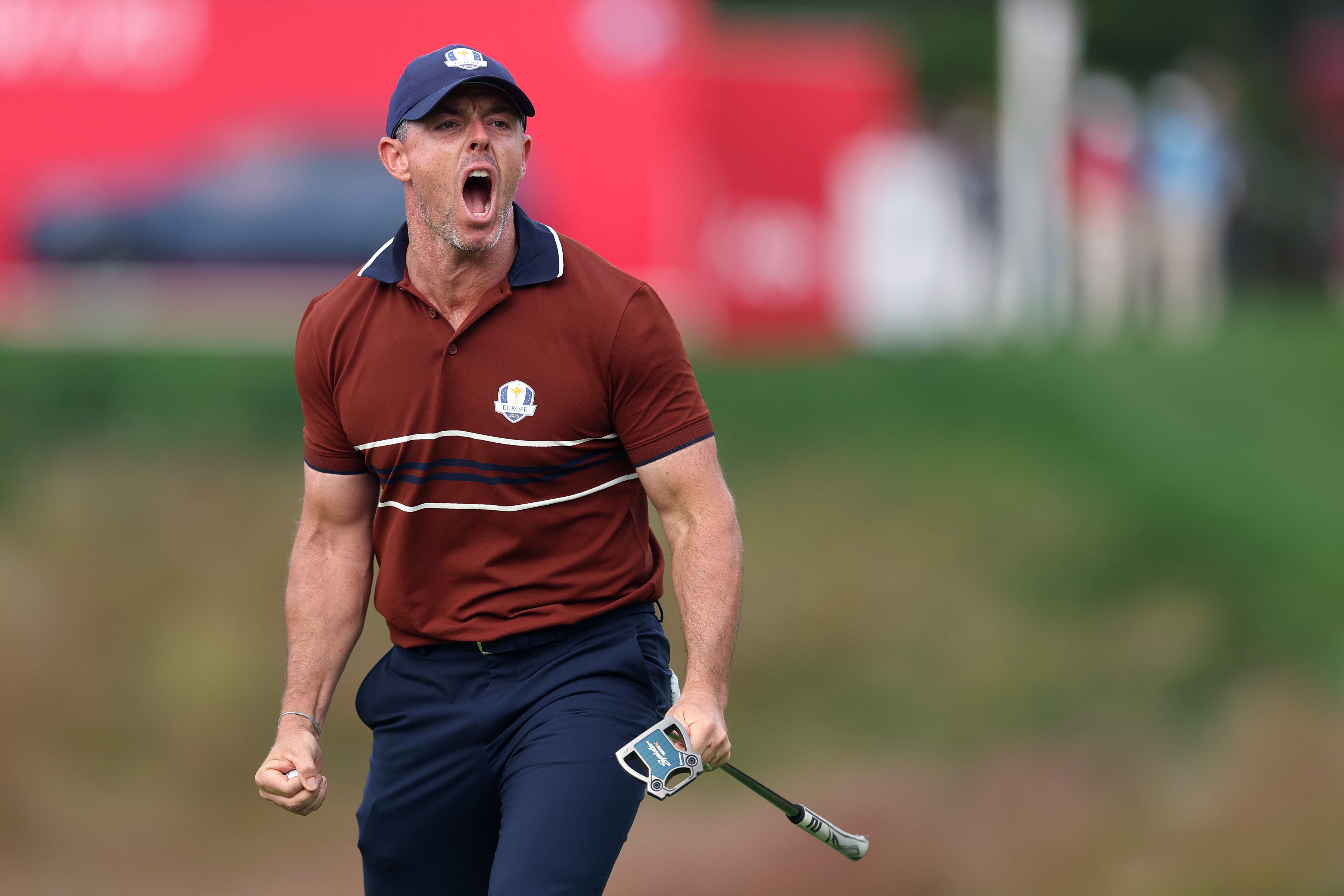 Golfer in sporty attire passionately celebrates on the course, holding a putter, during a tournament event