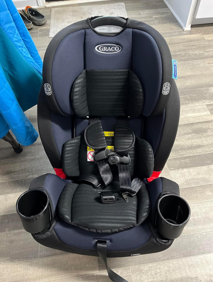 Graco kid  car   spot   with cupful  holders, information   harness, and padding, placed connected  a woody  floor