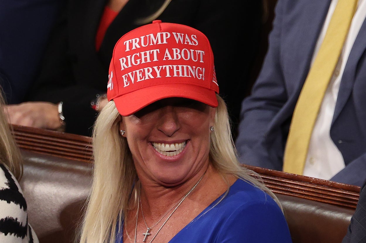 A person wearing a red cap with "Trump Was Right About Everything!" seated at a formal event
