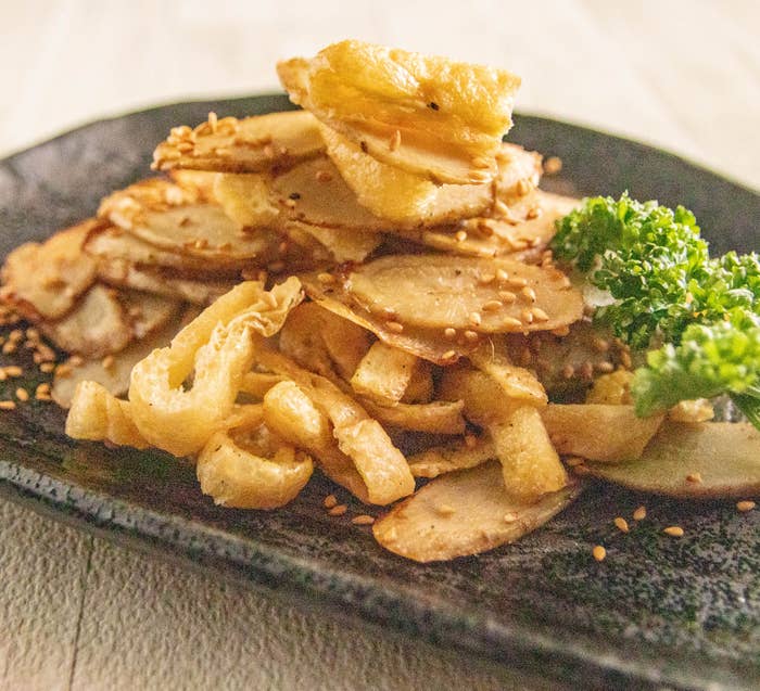 ごぼうと油揚げの香ばし炒め。盛り付けられたゴボウチップスと油揚げ。トッピングにゴマとパセリ飾り。