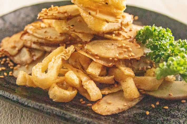ごぼうと揚げ物が盛られた皿に、ゴマが振りかけられ、パセリが添えられています。