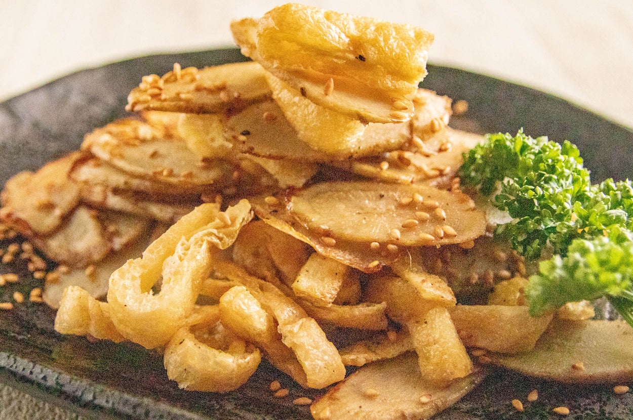 ごぼうと揚げ物が盛られた皿に、ゴマが振りかけられ、パセリが添えられています。