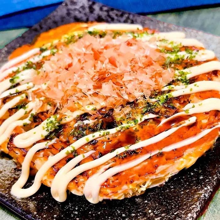 天ぷら粉を入れて作ったお好み焼きが皿に盛られ、マヨネーズとかつお節がかかっている。