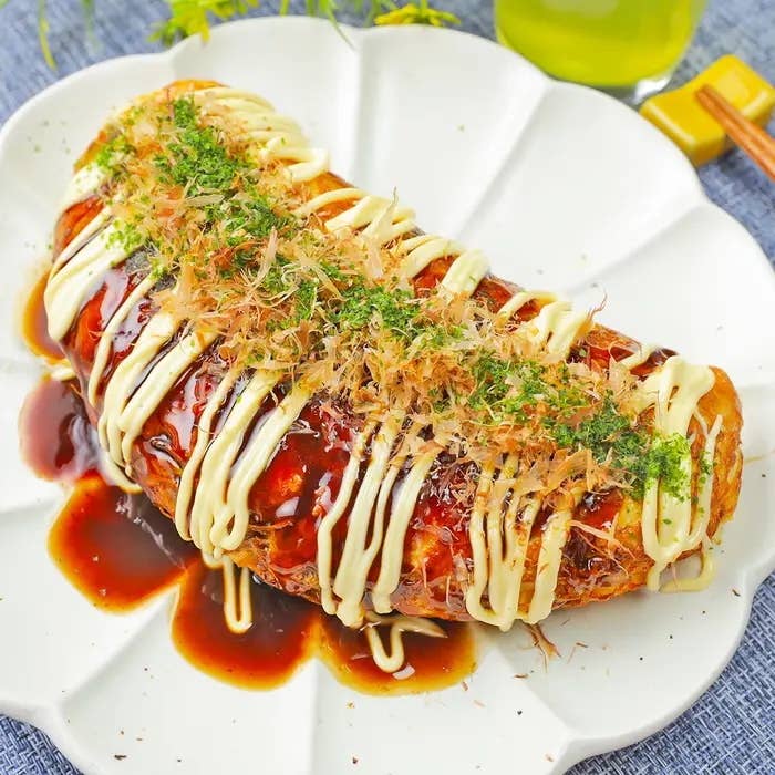 皿に盛られたキャベツと卵のお好み焼き。ソースとマヨネーズがかかり、青のりとかつお節がトッピングされています。