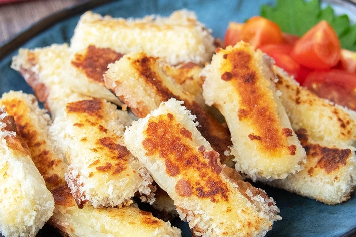 お皿に盛られたチーズ入りちくわのパン粉焼き。トマトが添えられている。
