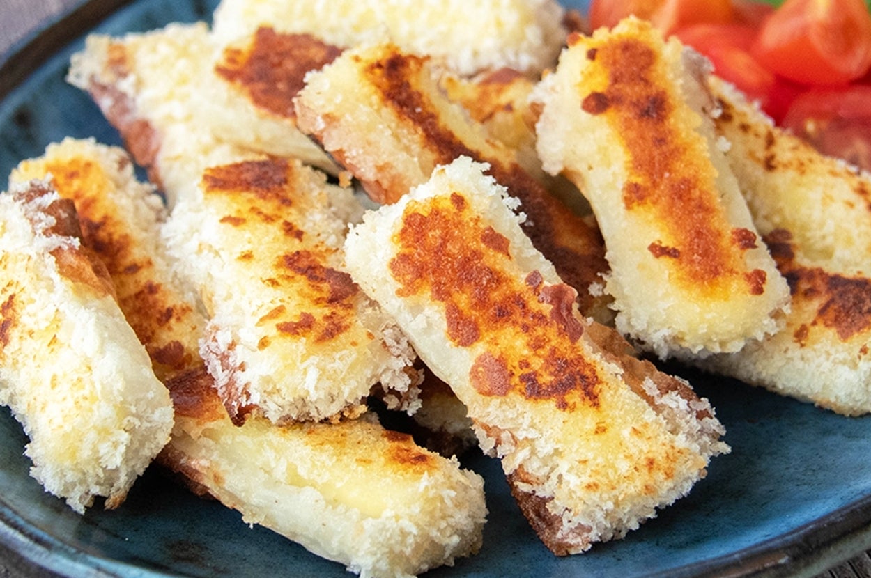 お皿に盛られたチーズ入りちくわのパン粉焼き。トマトが添えられている。
