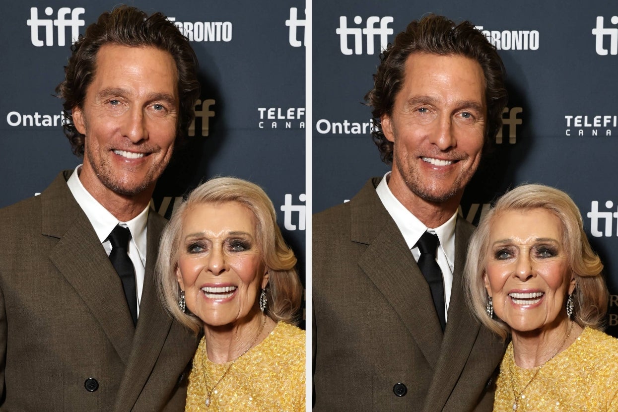 Two smiling individuals pose at a film event. The man wears a suit, and the woman has elegant attire with a shimmery texture
