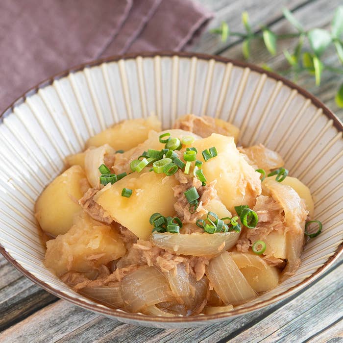 じゃがいも、玉ねぎ、ツナを使った料理が和風の器に盛られている。上に刻んだねぎがトッピングされている。
