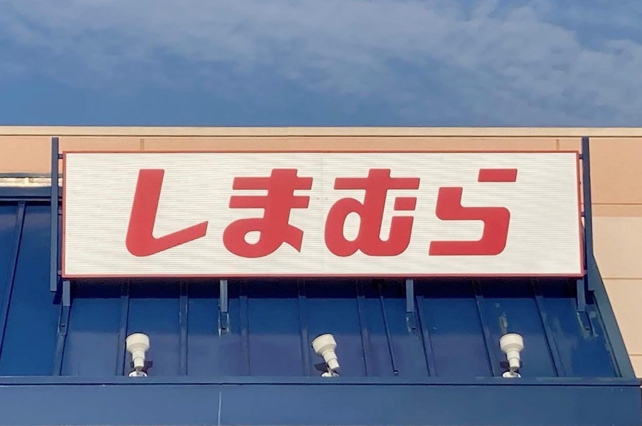 A sign above a store entrance displays "しまむら" in Japanese katakana script