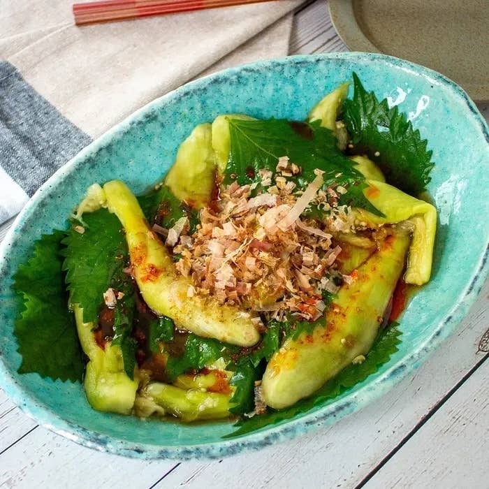 皿に盛られた唐辛子と青じその料理。トッピングに鰹節がのっている。