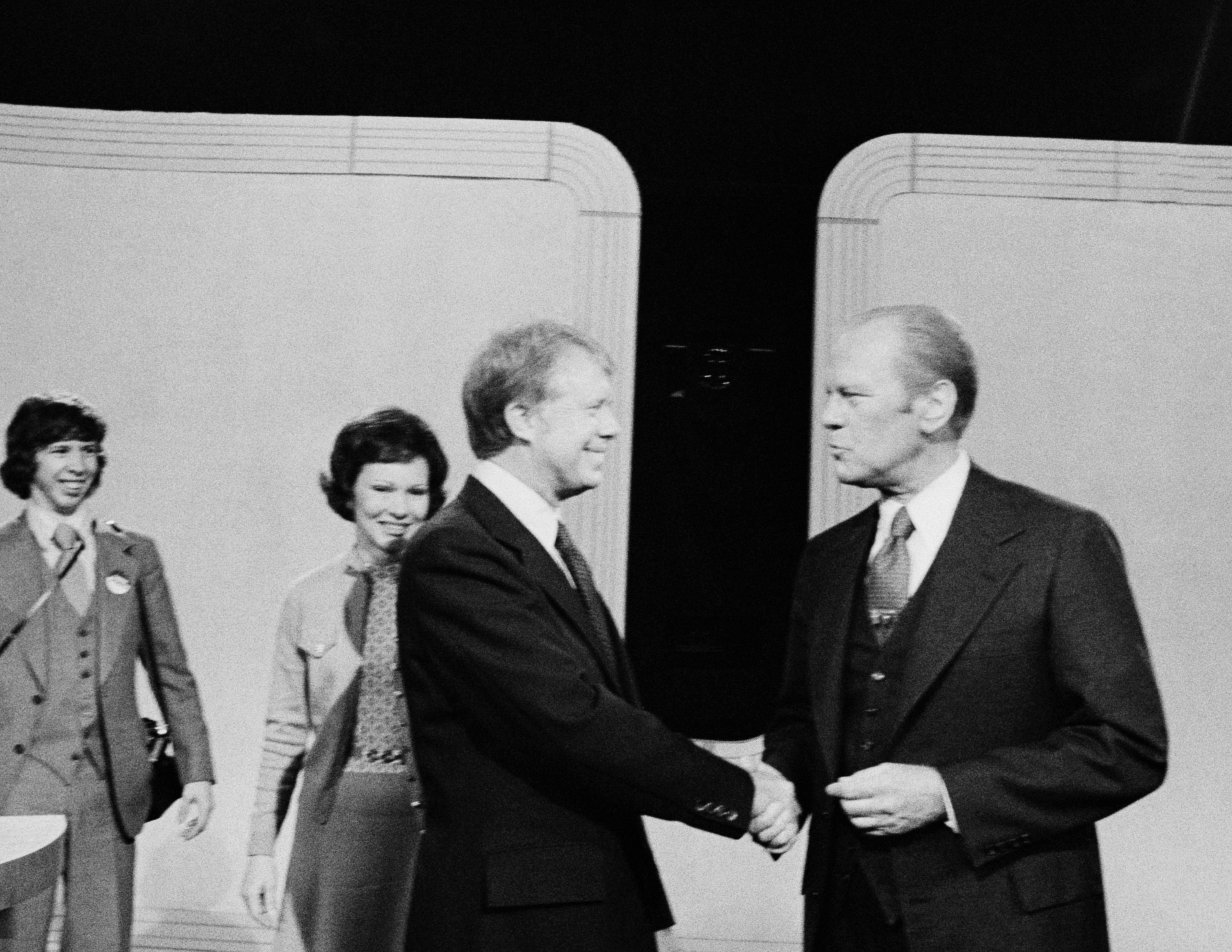 Two men successful suits shaking hands connected a stage, with 4 radical lasting down them. It appears to beryllium a ceremonial lawsuit oregon statement setting