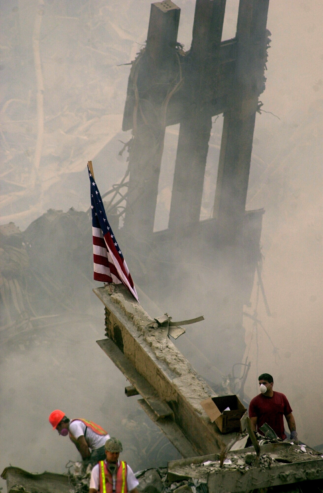 American emblem connected alloy beam astatine World Trade Center tract post-9/11, with workers wearing hard hats and masks amidst fume and debris