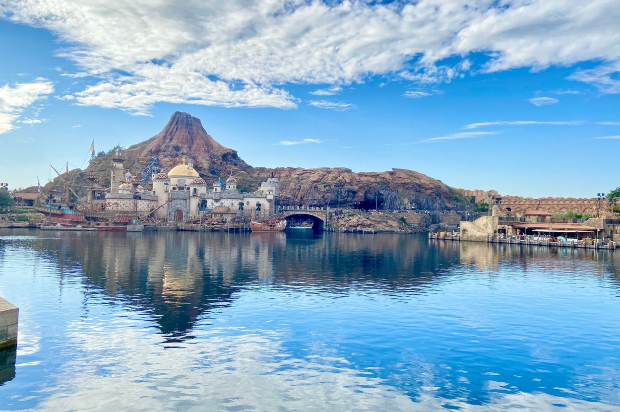 湖面に反射する山と建物。澄んだ空と静かな水面が広がる風景。