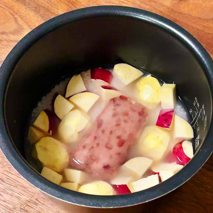 炊飯器にさつまいもが入った材料が見えます。調理前の状態です。