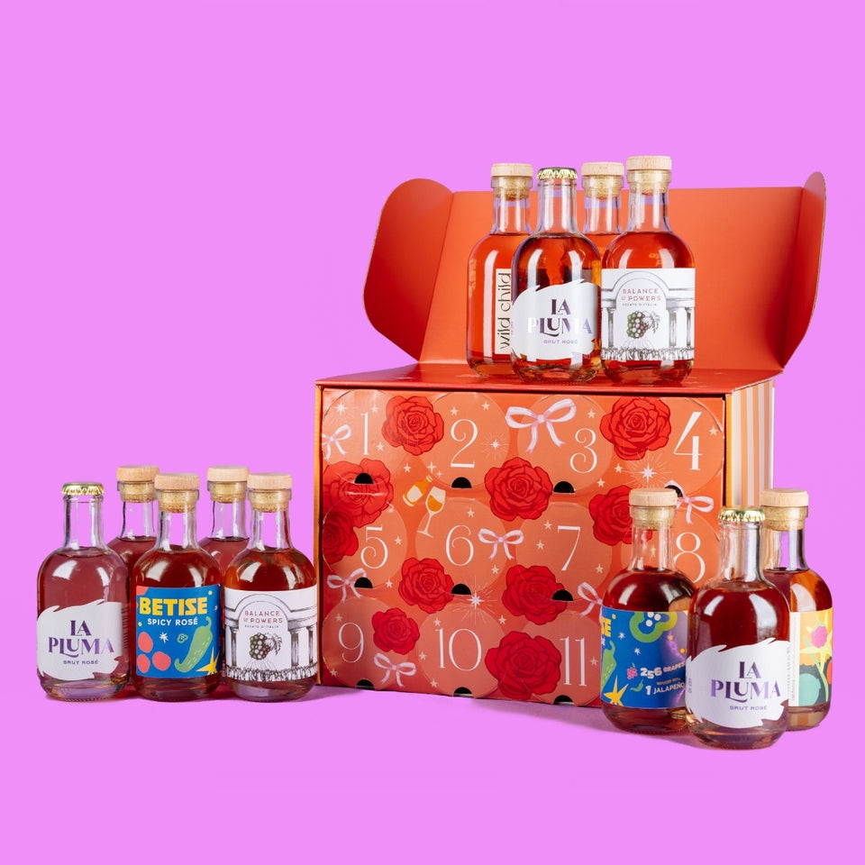 Advent calendar with 12 mini bottles of rum arranged in front, each labeled with unique designs