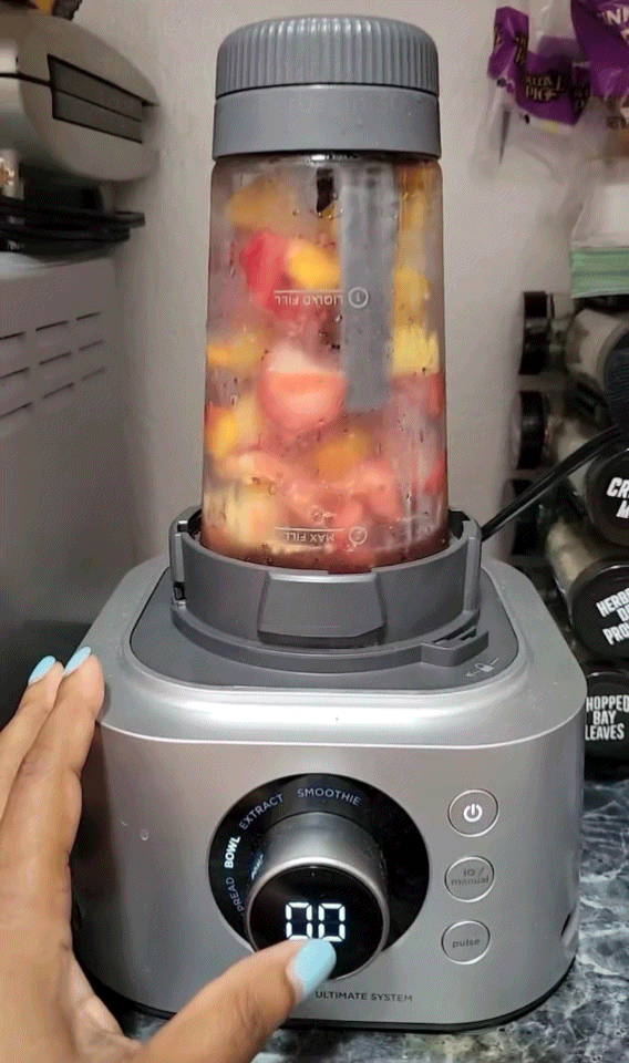 Hand operating a blender filled with effect   pieces, showing the smoothie mounting  connected  the display