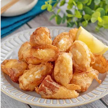 皿に盛られた揚げた食べ物とレモン。