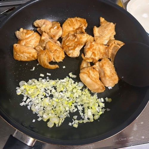 フライパンで鶏肉とネギを炒めている調理中の様子。